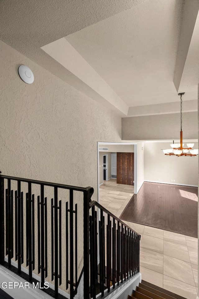 425 Golden Springs Dr, El Paso, TX 79912 - stairs featuring a chandelier, a textured wall, and tile patterned flooring