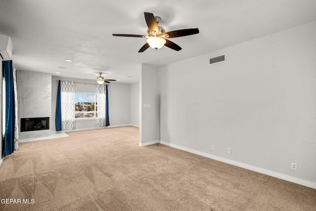 425 Golden Springs Dr, El Paso, TX 79912 - unfurnished living room featuring a fireplace, visible vents, an AC wall unit, light carpet, and baseboards