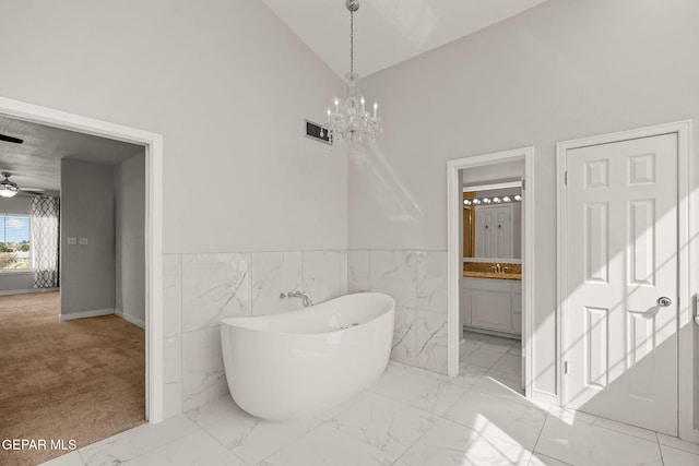 425 Golden Springs Dr, El Paso, TX 79912 - bathroom with visible vents, marble finish floor, a freestanding bath, high vaulted ceiling, and ceiling fan with notable chandelier