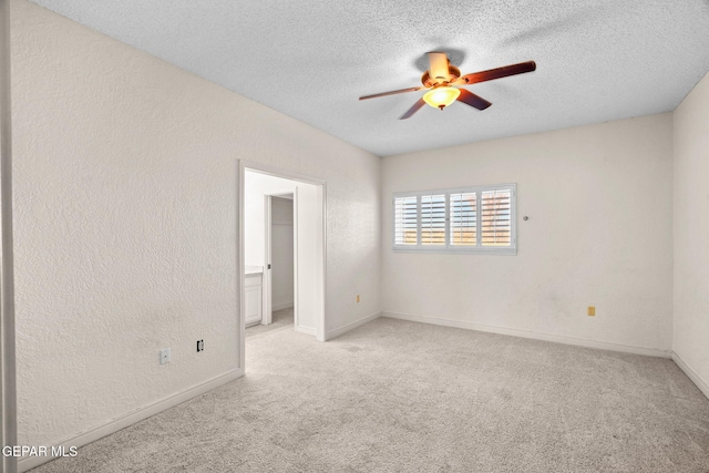 425 Golden Springs Dr, El Paso, TX 79912 - empty room featuring light colored carpet, a textured wall, a ceiling fan, a textured ceiling, and baseboards
