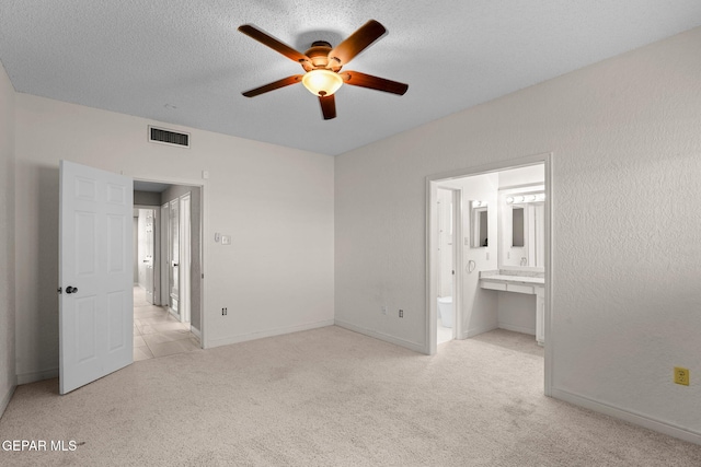 425 Golden Springs Dr, El Paso, TX 79912 - unfurnished bedroom with a textured ceiling, connected bathroom, light colored carpet, visible vents, and baseboards