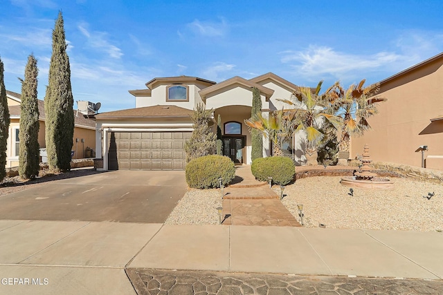 view of front of home featuring a garage, concrete driveway, and stucco siding