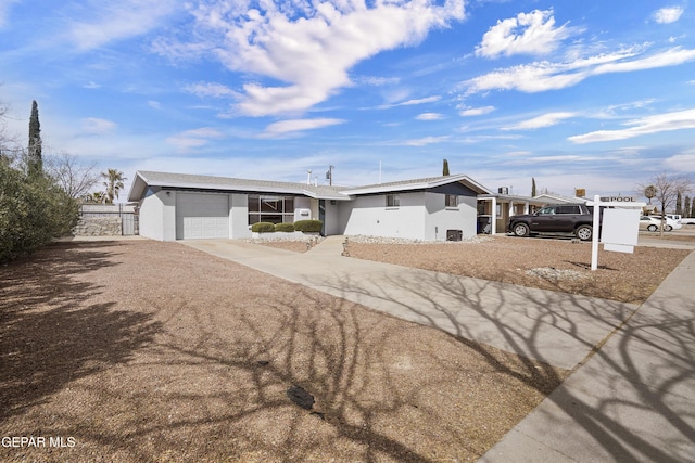 view of front of house featuring concrete driveway, an attached garage, fence, and stucco siding