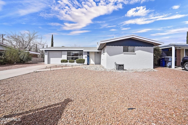 view of front of home featuring driveway, a garage, and brick siding