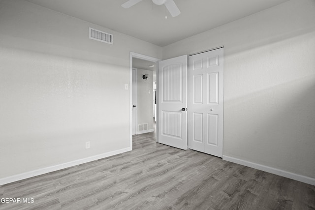 unfurnished bedroom with wood finished floors, visible vents, and baseboards