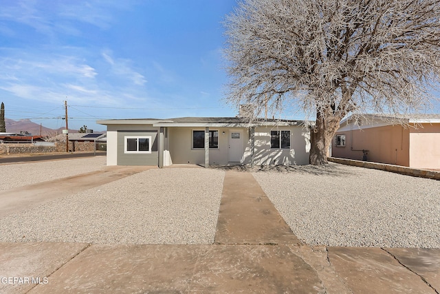 single story home featuring a chimney and stucco siding