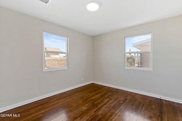 unfurnished room with dark wood finished floors and baseboards