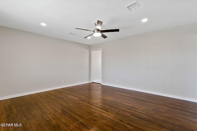 spare room with ceiling fan, dark wood-style flooring, visible vents, and baseboards