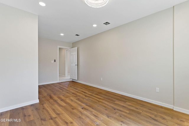 spare room with recessed lighting, visible vents, baseboards, and wood finished floors