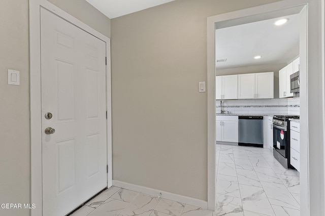 foyer featuring recessed lighting, marble finish floor, and baseboards