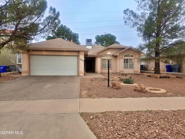 ranch-style house featuring a garage, concrete driveway, and stucco siding