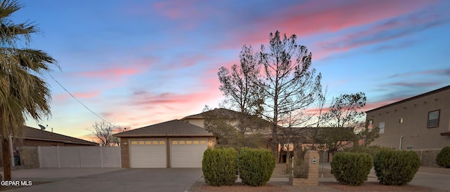 view of front of house featuring concrete driveway, fence, and an attached garage