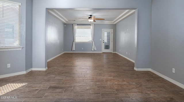 spare room with ceiling fan, baseboards, dark wood finished floors, and crown molding