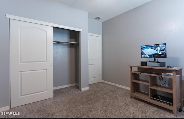 carpeted bedroom featuring baseboards, visible vents, and a closet