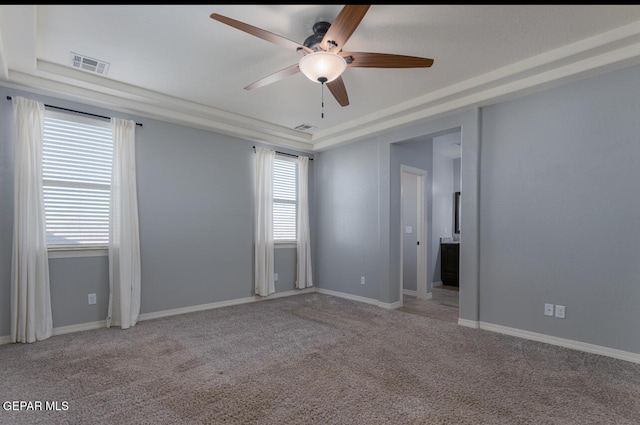 unfurnished room featuring light colored carpet, baseboards, visible vents, and a tray ceiling