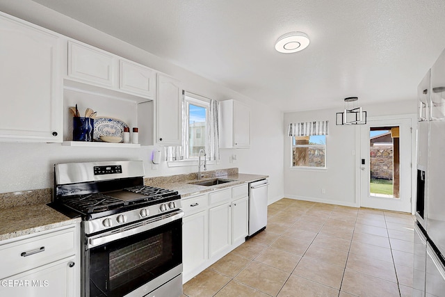 kitchen featuring pendant lighting, open shelves, appliances with stainless steel finishes, white cabinets, and a sink