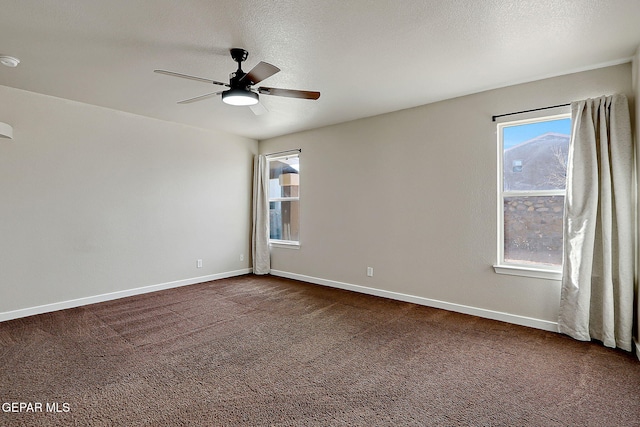 carpeted spare room with ceiling fan, a textured ceiling, and baseboards