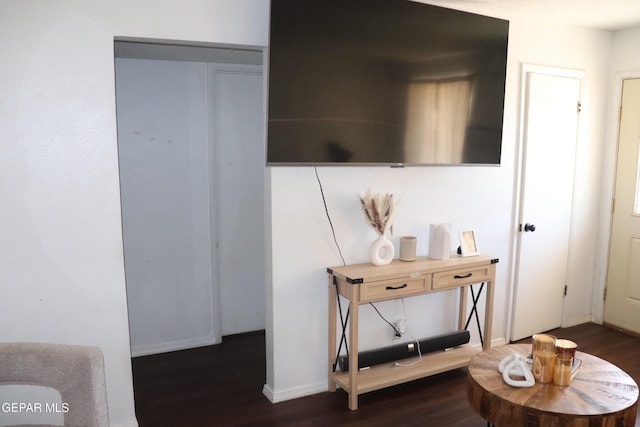 hall featuring dark wood-type flooring and baseboards