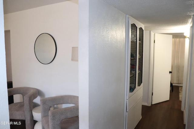 hallway featuring dark wood finished floors and a textured ceiling