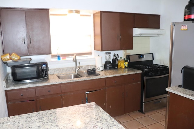 kitchen with stainless steel appliances, decorative backsplash, light tile patterned flooring, a sink, and under cabinet range hood