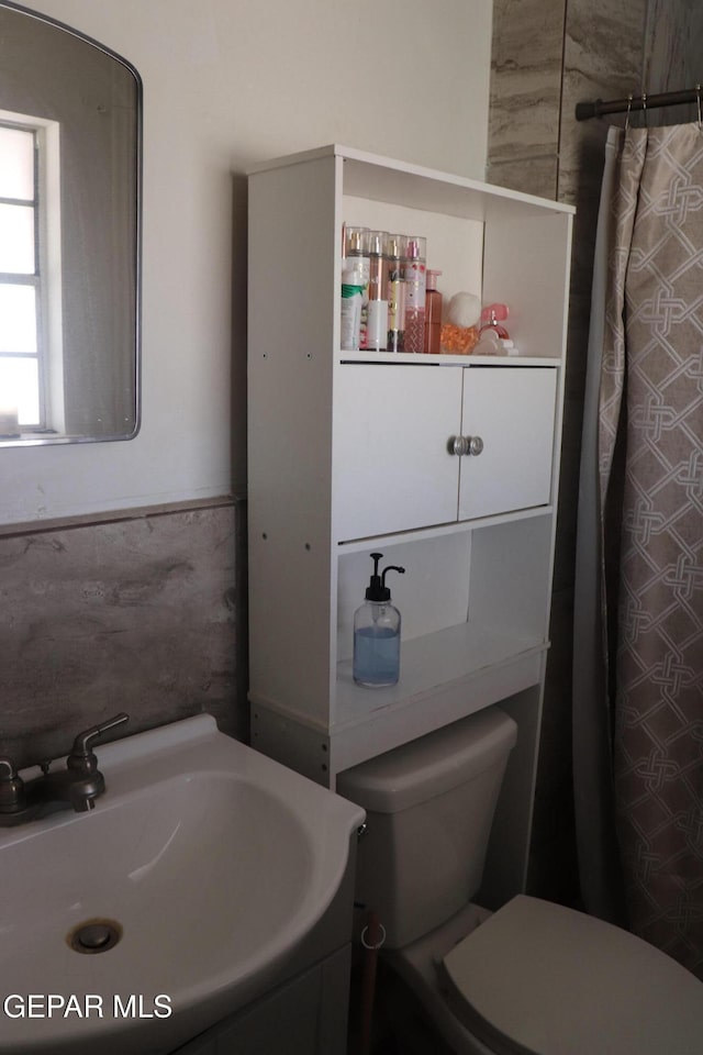 bathroom featuring a shower with shower curtain, vanity, and toilet