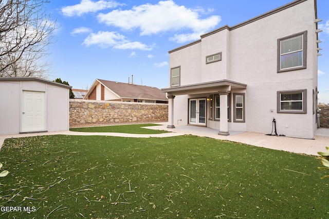 rear view of house with a lawn, french doors, a patio, and stucco siding