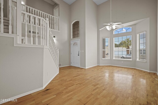 entryway with stairway, wood finished floors, a ceiling fan, and baseboards