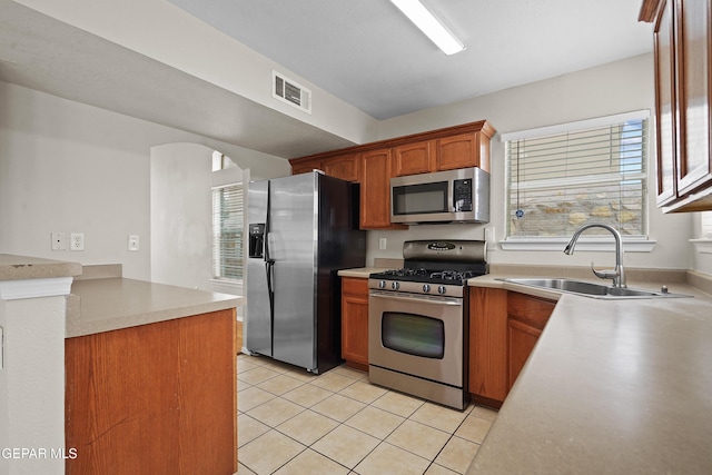 kitchen featuring light tile patterned flooring, a sink, visible vents, light countertops, and appliances with stainless steel finishes