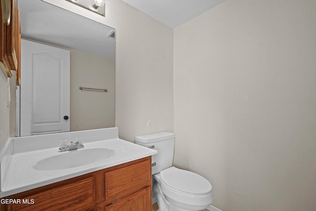 half bath featuring toilet and vanity