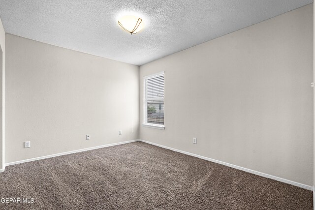 unfurnished room featuring a textured ceiling, carpet flooring, and baseboards