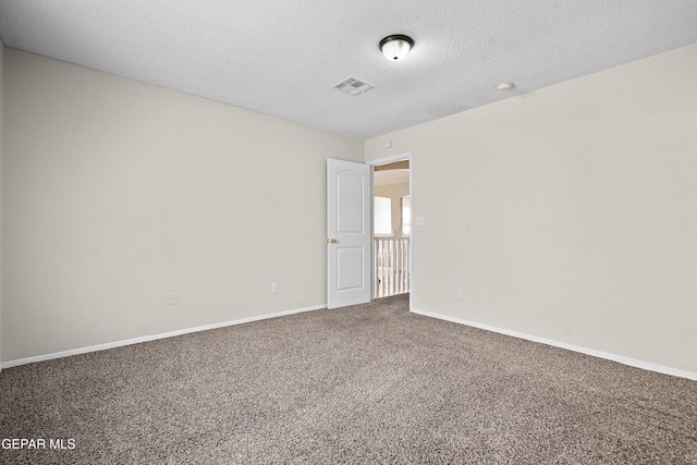 carpeted empty room featuring visible vents, a textured ceiling, and baseboards