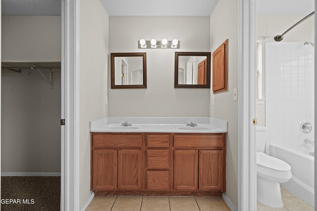 bathroom featuring  shower combination, a sink, toilet, and double vanity