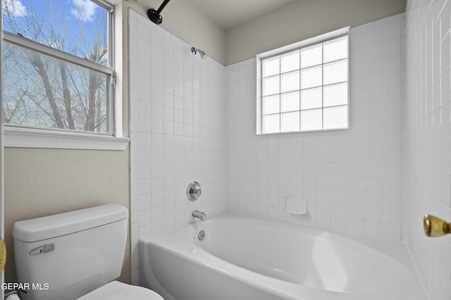 bathroom featuring bathtub / shower combination and toilet