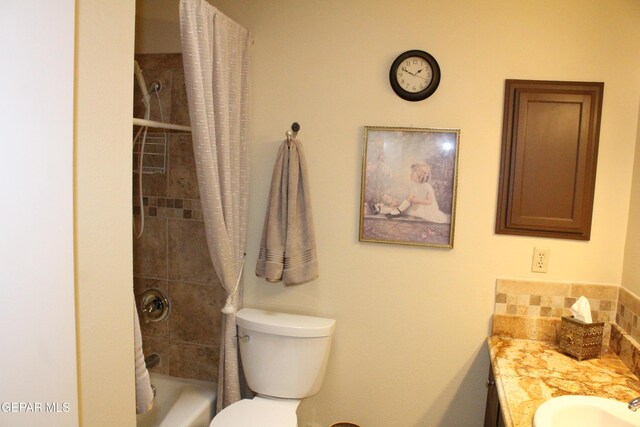 bathroom featuring toilet, shower / bath combo with shower curtain, and vanity