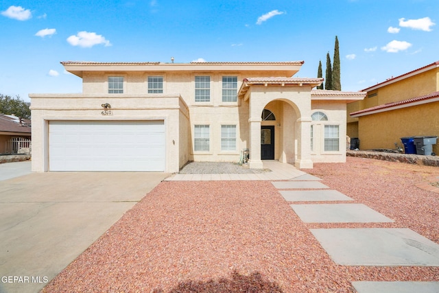 mediterranean / spanish house featuring driveway, a tiled roof, and stucco siding