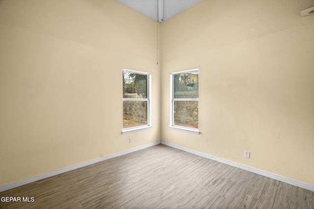 empty room featuring light wood finished floors and baseboards