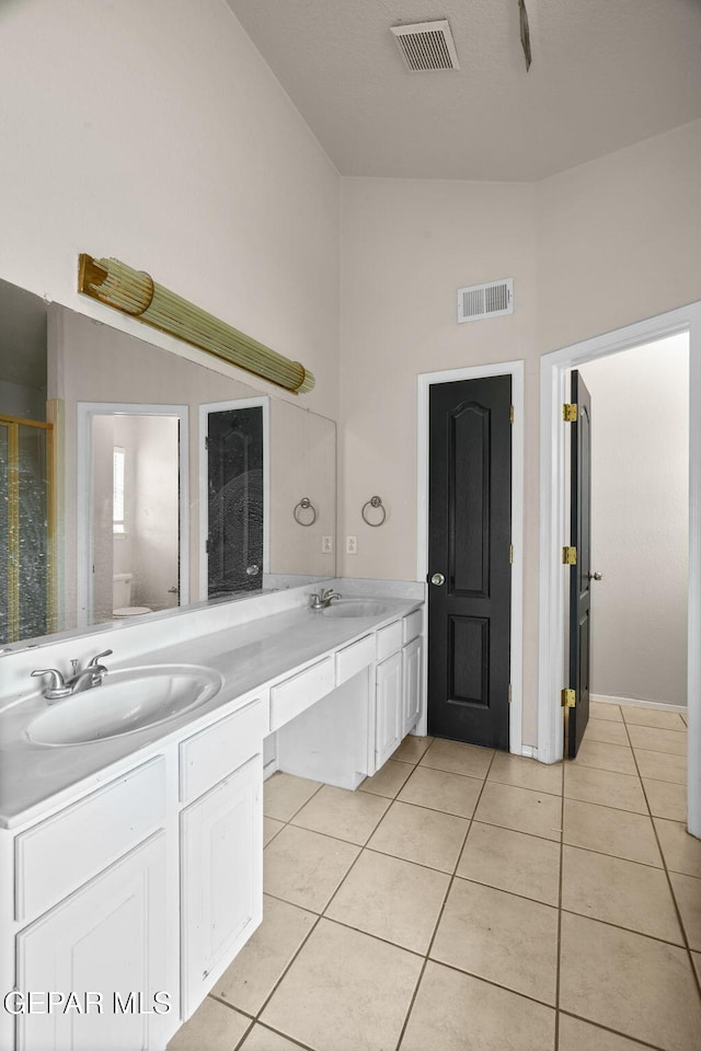 full bath with double vanity, tile patterned flooring, visible vents, and a sink