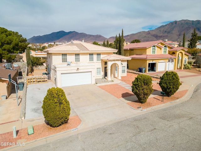 view of front of house with a garage, a residential view, a mountain view, and stucco siding