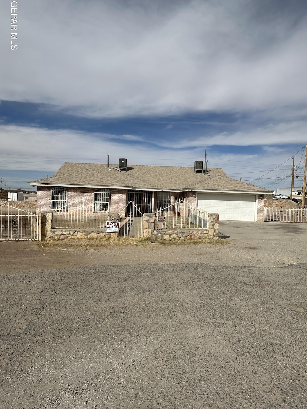 ranch-style home with a garage, fence private yard, driveway, and roof with shingles