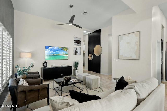 living area with light wood finished floors, visible vents, and a ceiling fan