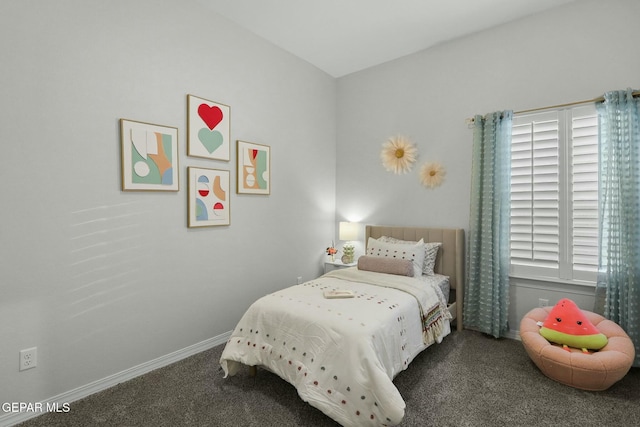 bedroom featuring dark colored carpet and baseboards