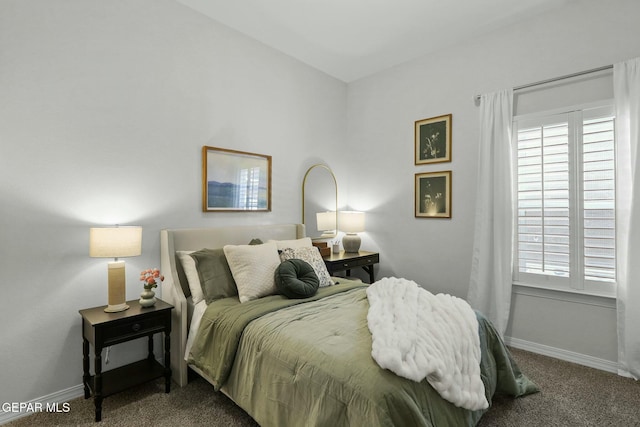 carpeted bedroom featuring multiple windows and baseboards