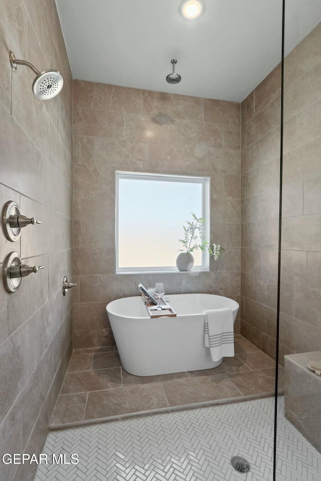 full bathroom featuring a soaking tub, tile walls, and a walk in shower