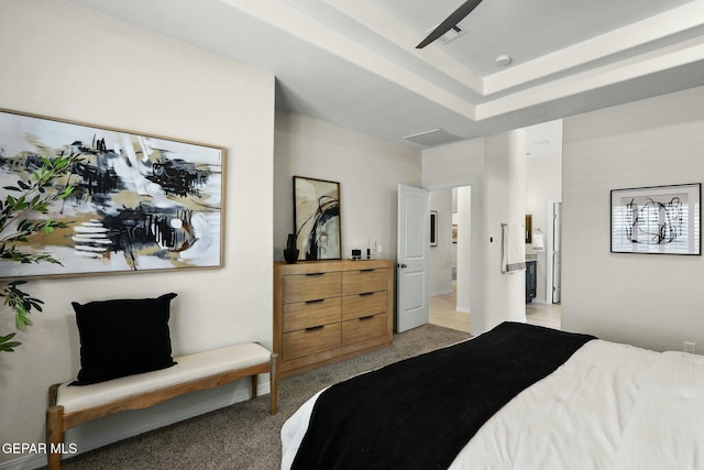 bedroom with a tray ceiling and light colored carpet