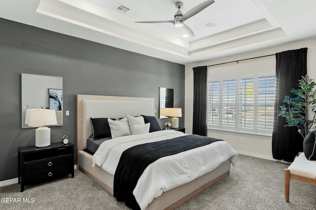 bedroom featuring carpet floors, baseboards, visible vents, and a raised ceiling