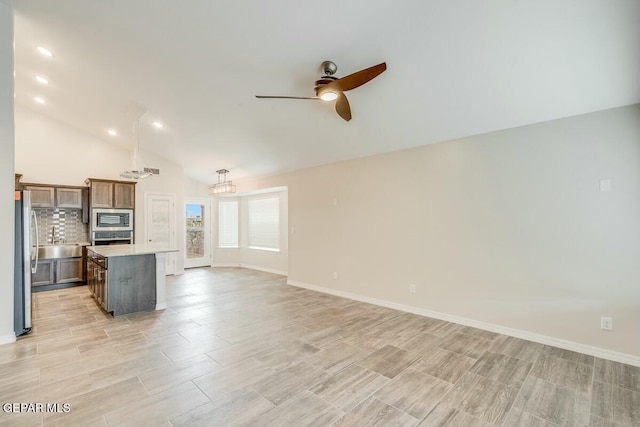 kitchen with open floor plan, stainless steel appliances, light countertops, and a center island