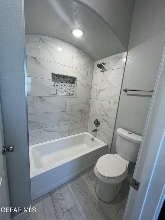 bathroom featuring toilet, shower / washtub combination, and wood finished floors