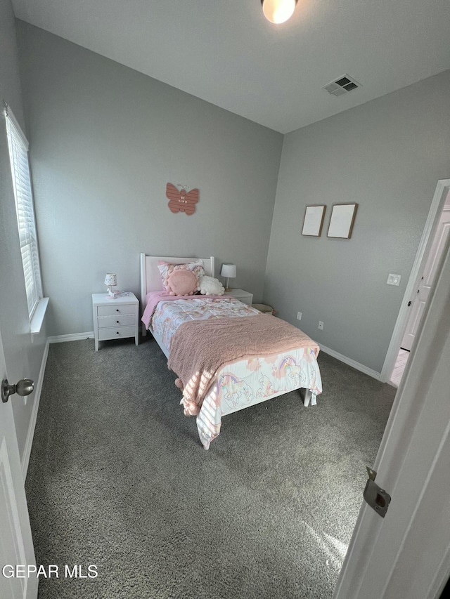 bedroom with visible vents, dark carpet, and baseboards