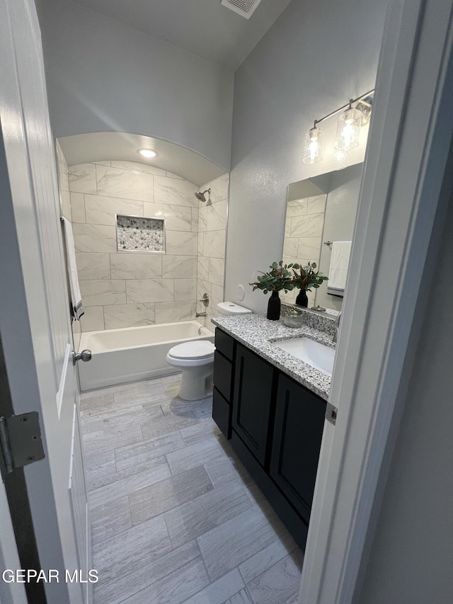 bathroom with  shower combination, visible vents, vanity, and toilet