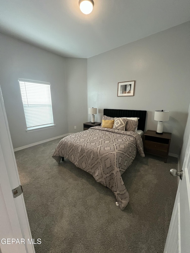 bedroom featuring baseboards and dark colored carpet